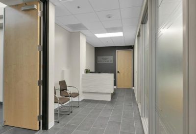 Reception area with a modern white desk and grey tiled flooring.