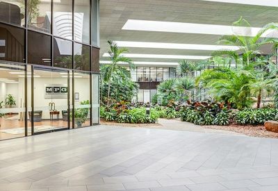 Spacious indoor atrium lobby featuring lush tropical plants and a large skylight.