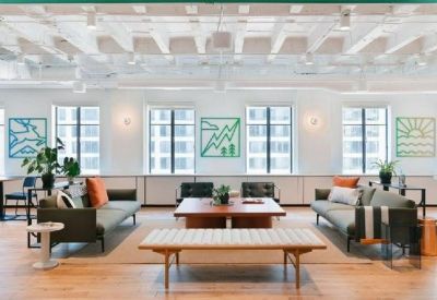 Spacious communal lounge with green wall art and comfortable sofas.