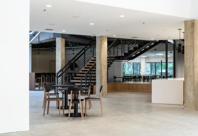 Spacious modern lobby with a wooden staircase and casual seating area.
