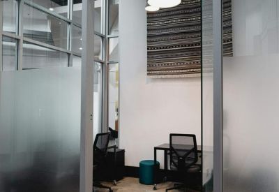 Private office suite for two people featuring glass walls, pendant lighting, and a patterned rug.