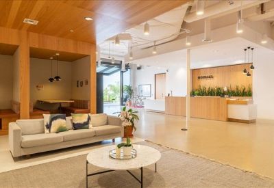 Cozy break area with blue ottoman seating, a wooden coffee table, and a patterned rug.