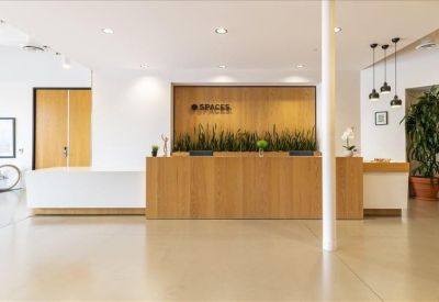 Spacious lobby lounge with a grey sofa, marble coffee table, and wood-paneled alcoves.