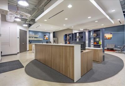 Spacious reception area featuring a wooden front desk and bright modern lighting.