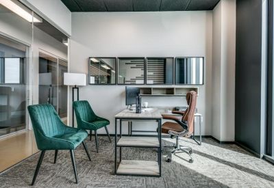 Office suite with emerald green chairs and three framed art pieces on the wall.