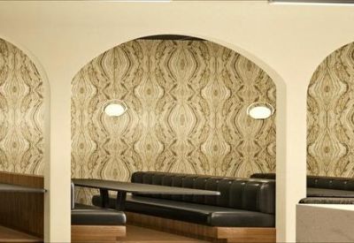 Detailed view of cafe booths with arched entries and patterned wallpaper.