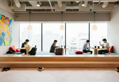Sunlit window-side working area with a raised wooden platform and colorful mural.