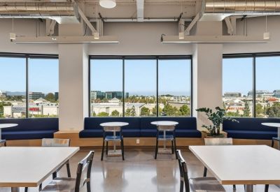 Vibrant breakout area featuring window-side seating and modern café tables.