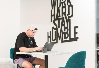 Bright breakout space with teal accent chairs and motivational wall art.