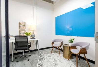 Private internal office featuring a blue accent wall and two grey guest chairs.