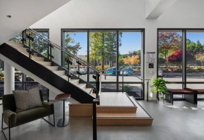 Lobby area featuring a modern staircase, green accent wall, and indoor plant.