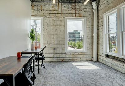 Bright office suite with exposed brick walls and large windows.