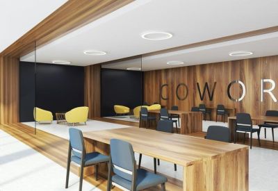 Coworking space featuring long wooden tables, blue chairs, and a warm wood-paneled feature wall.