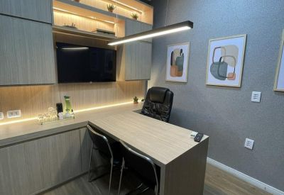 Modern office suite with wood-tone cabinetry, L-shaped desk, and abstract wall art.