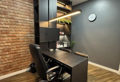 Private office at Shopping Seaway with a brick feature wall and contemporary black furniture.