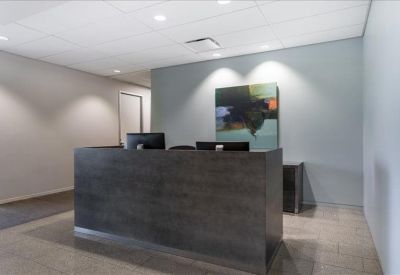 Sleek dark wood reception desk in a well-lit entrance area with modern art.