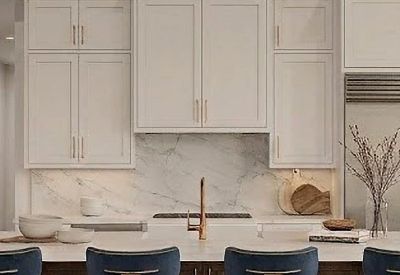 Modern communal kitchen area featuring white cabinets, wood paneling, and blue velvet bar stools.