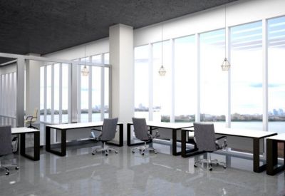 Modern open-plan workspace with white desks and floor-to-ceiling windows overlooking the water.