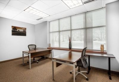 Two-person office with large window and simple decor.