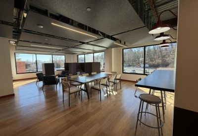 Spacious open-plan communal area with light wood floors and modern seating.