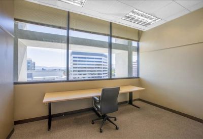 Contemporary office kitchen with wood-finish cabinets and stainless steel appliances.
