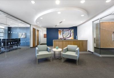 Professional reception area with a wooden front desk and comfortable blue seating.