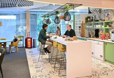 Compact three-person office suite with light wood desks and ergonomic chairs.