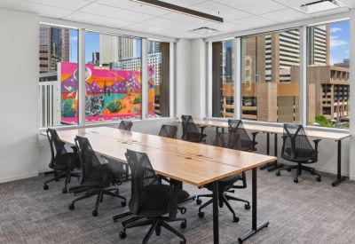 Team workstation area with large windows overlooking a colorful city mural.
