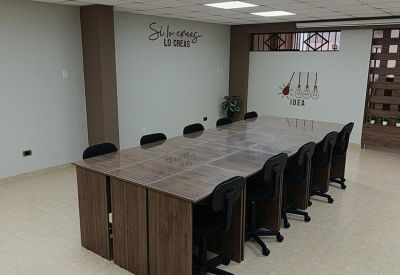 Large wooden conference table with black chairs in a professional meeting room.