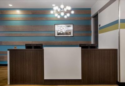 Professional reception desk with a wood-paneled front and a teal-striped feature wall.