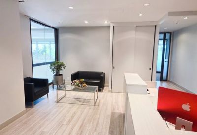 Lobby waiting area with black leather armchairs and a glass coffee table.