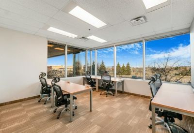 Sun-drenched corner office with four desks and large windows.