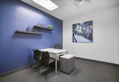 Private office featuring a blue accent wall, shelving, and a small meeting table.