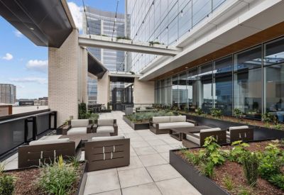 Outdoor rooftop terrace with modern patio furniture and planter boxes.