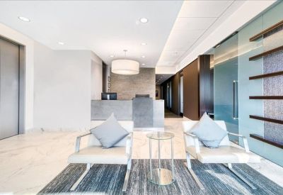 Sleek reception area with grey front desk and comfortable lounge seating.