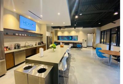Office kitchen and break area featuring a long island, white stools, and a large built-in aquarium.