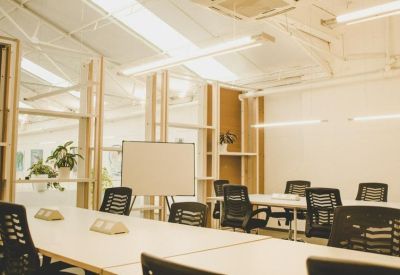 Bright conference room with a whiteboard, ergonomic black chairs, and natural wood partitions.