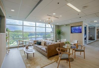 Spacious lounge area with leather sofas, floor-to-ceiling windows, and natural light.