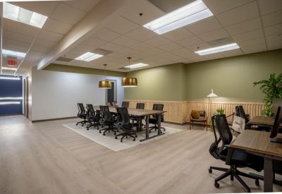 Large professional meeting room with a central conference table and ergonomic black chairs.