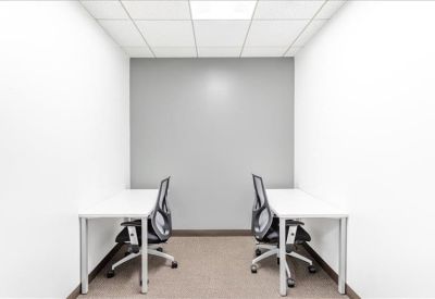 Small private office suite featuring two white desks and ergonomic mesh chairs.
