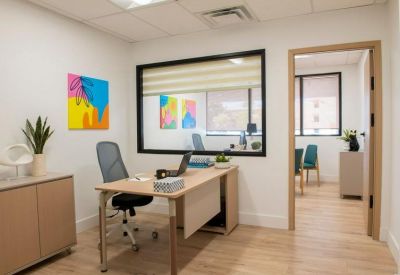 Private office with a large internal window viewing into a common area.