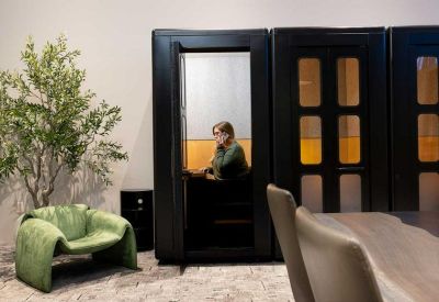 Meeting room with a long live-edge table, comfortable leather armchairs, and abstract wall art.