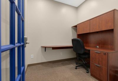 Private office suite with built-in wooden desk and cabinetry.