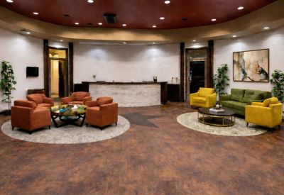 Spacious reception lobby with a curved front desk and colorful orange and yellow seating areas.