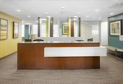 Professional reception area with a wood-fronted desk and abstract wall art.