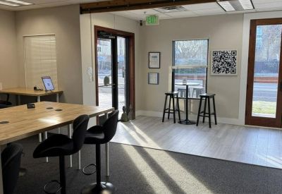 Brightly lit breakout area with high-top seating and large windows providing natural light.