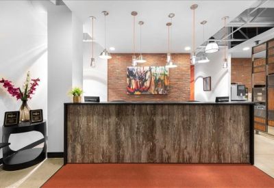 Welcoming reception desk with a wood-grain finish and a warm brick background.