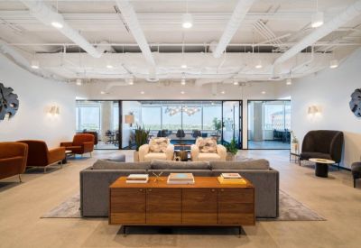 Large open-plan reception and lounge area with diverse seating and view into a glass boardroom.