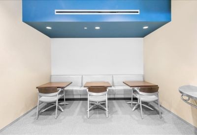 Café-style seating area with a bright blue architectural ceiling feature.