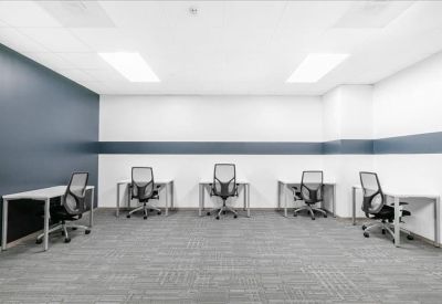 Open-plan coworking area with individual desks and a blue feature wall.